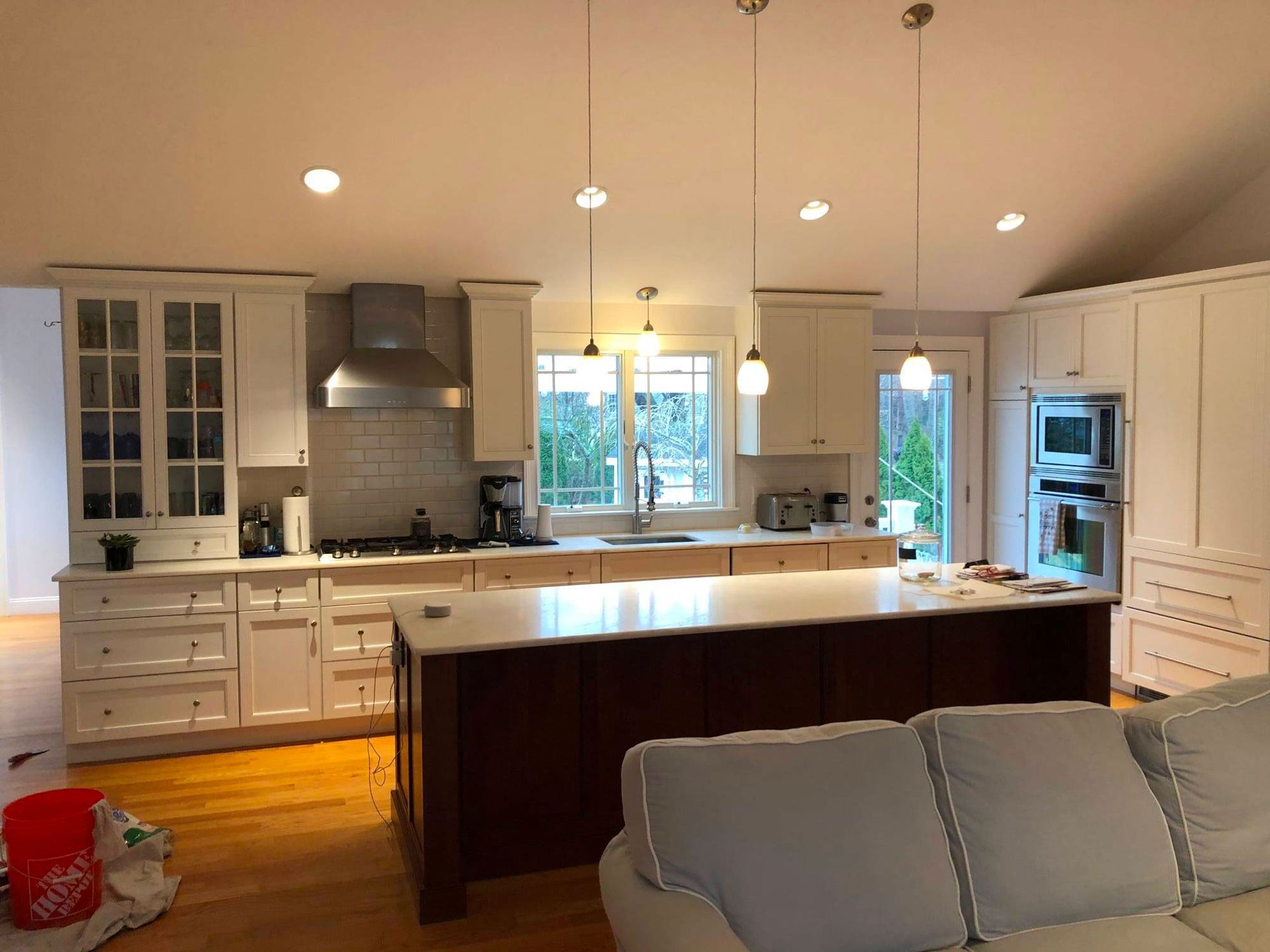 Kitchen with white cabinets, dark wood island, stainless steel appliances, and pendant lights.