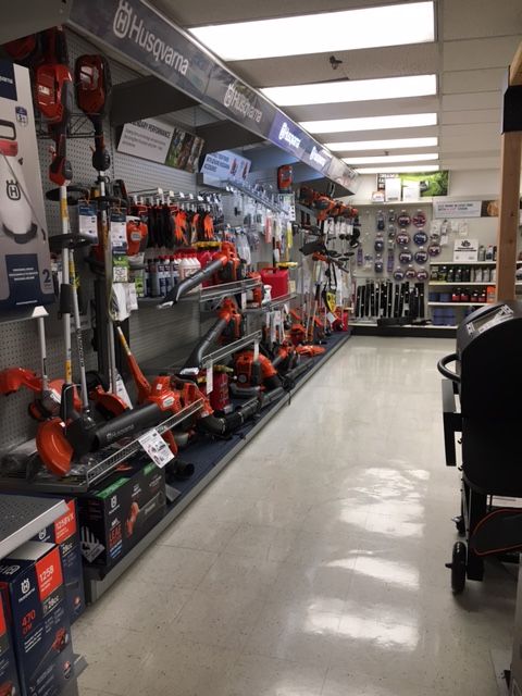 Rows of lawn and garden tools displayed in a retail store with overhead lighting.
