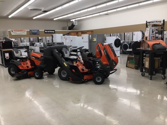 Lawn mowers on display in a store aisle