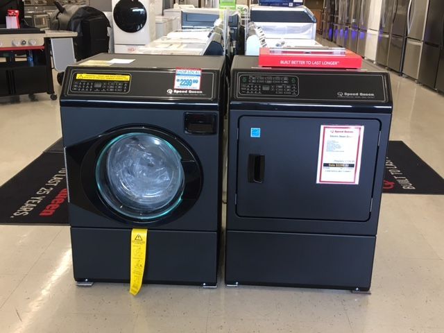 A black washing machine and dryer set in a store setting.