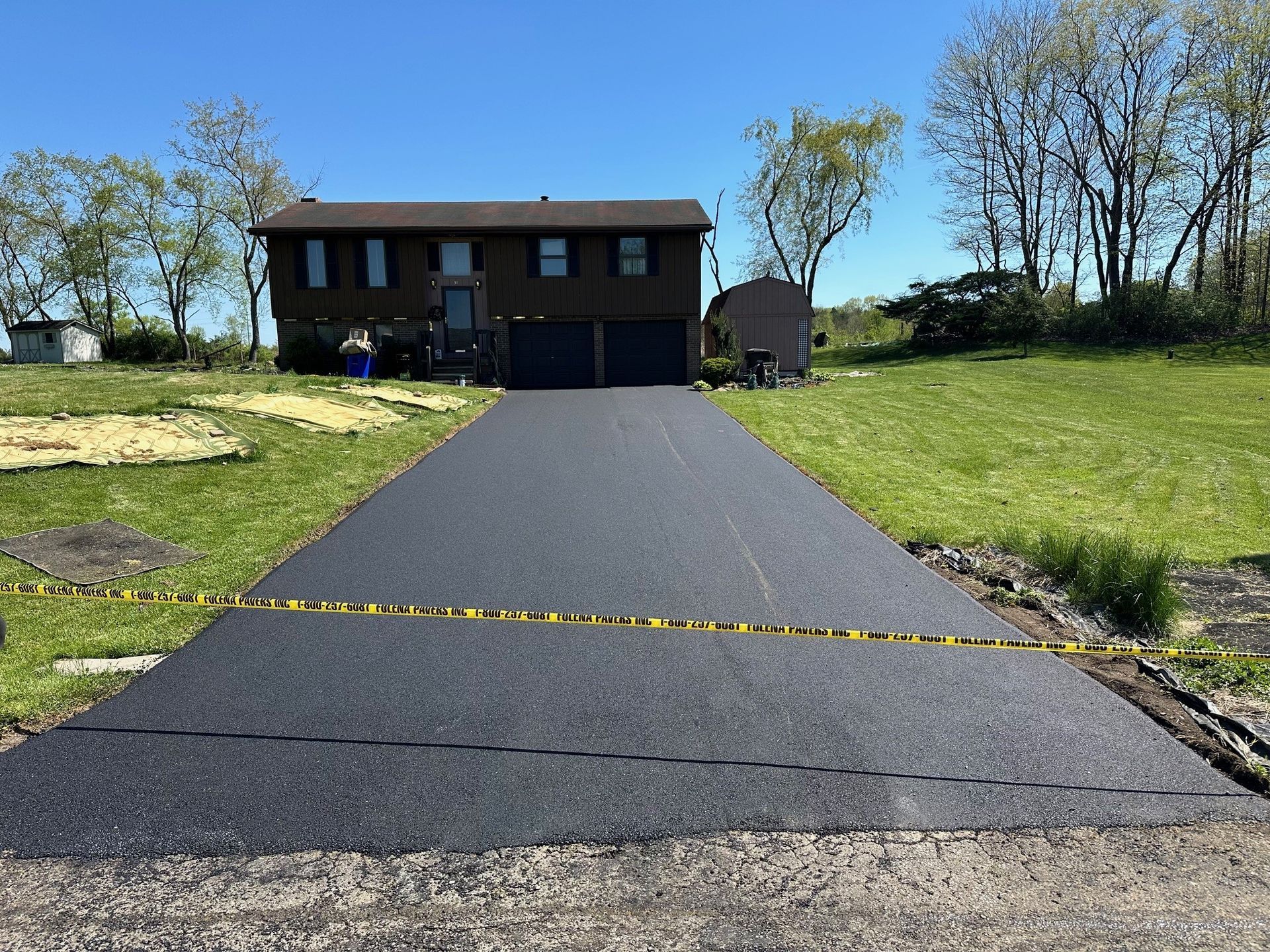 A black driveway leading to a large house