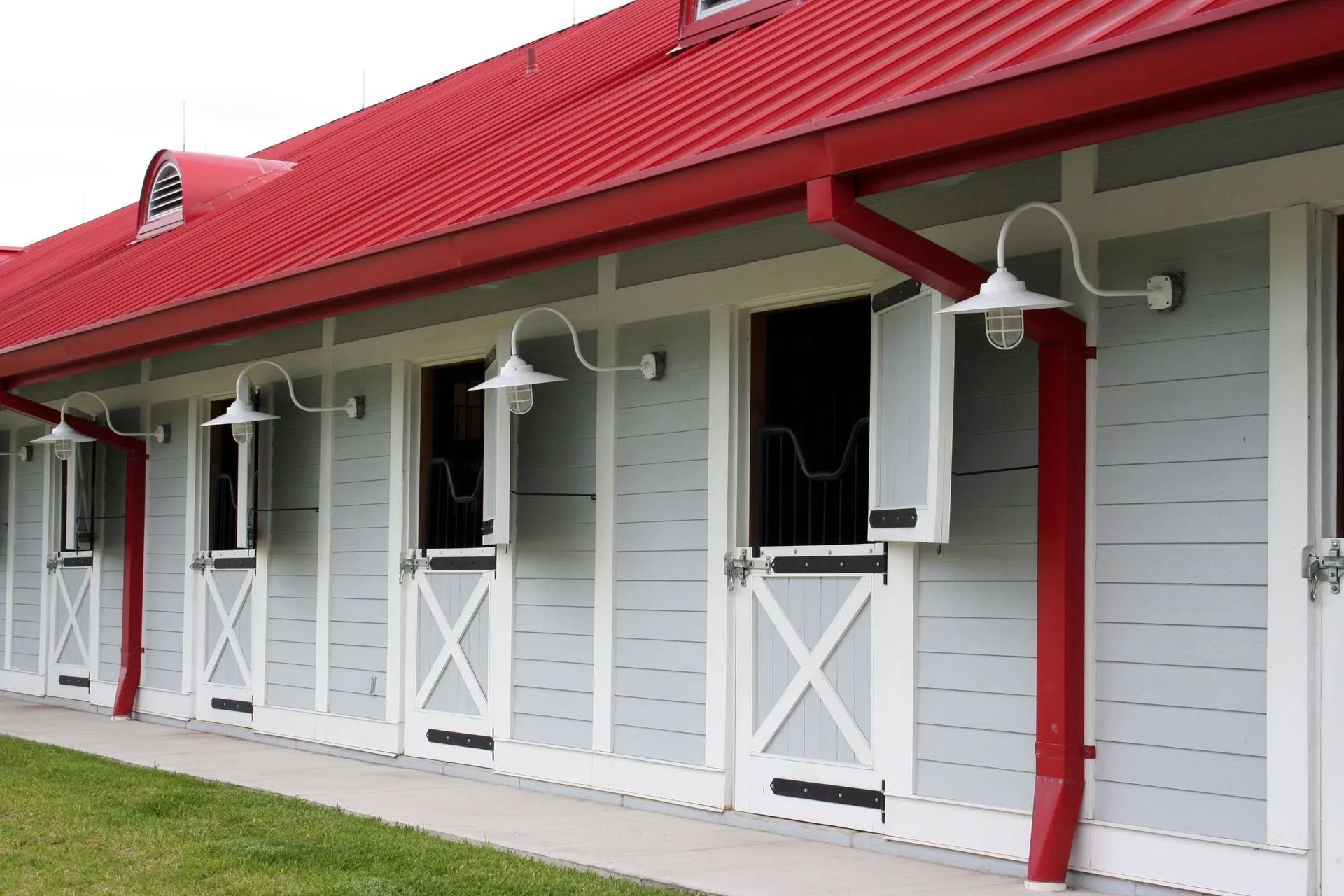 A row of horse stables with a red roof
