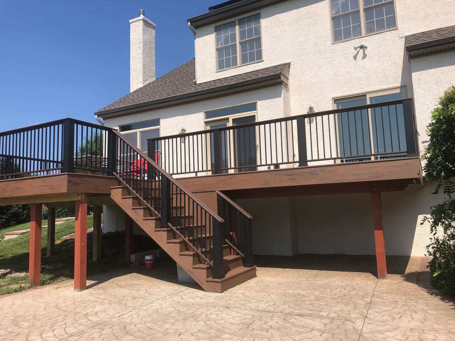 A large white house with a large deck and stairs