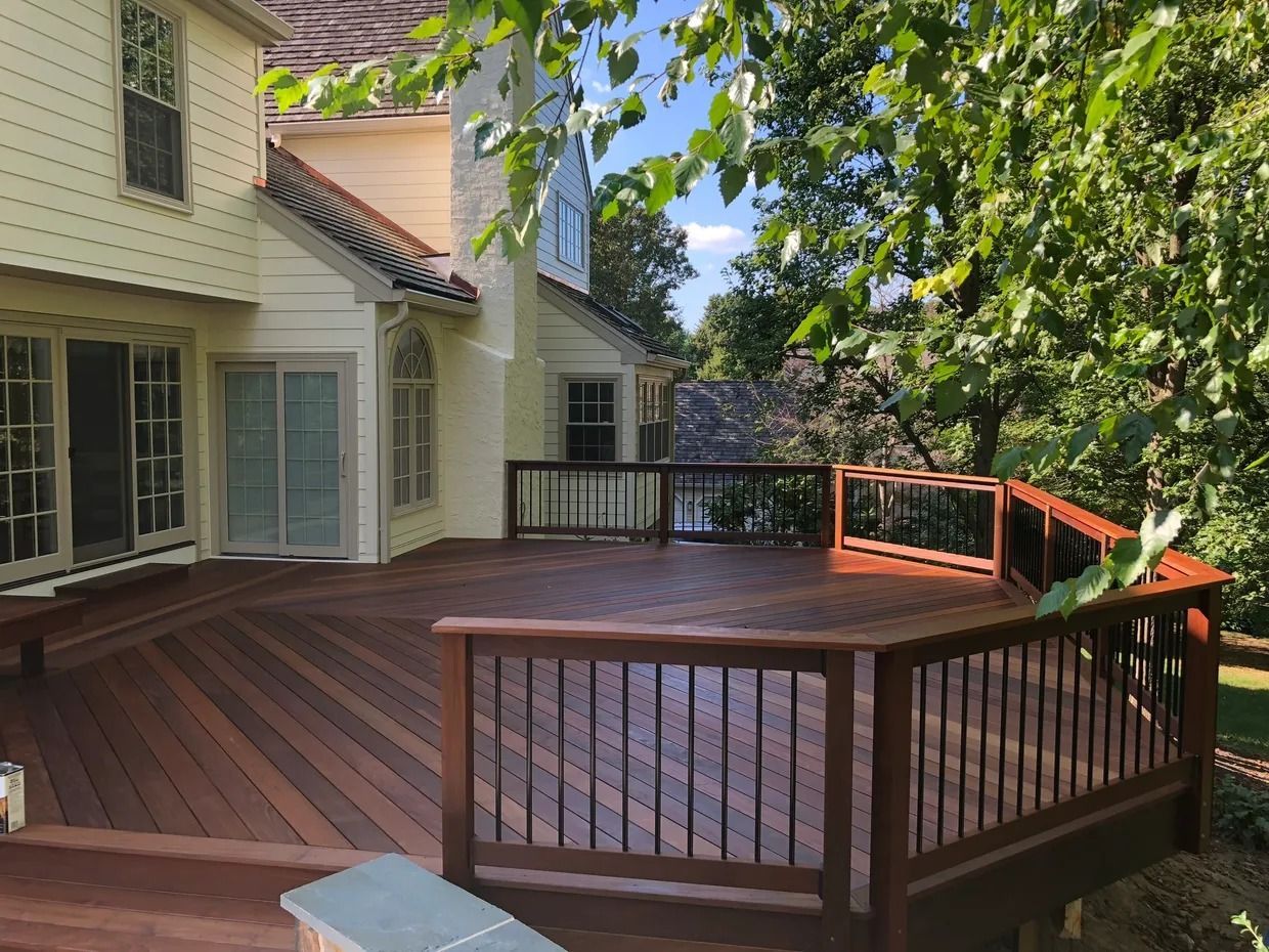 A large wooden deck is sitting in front of a house.