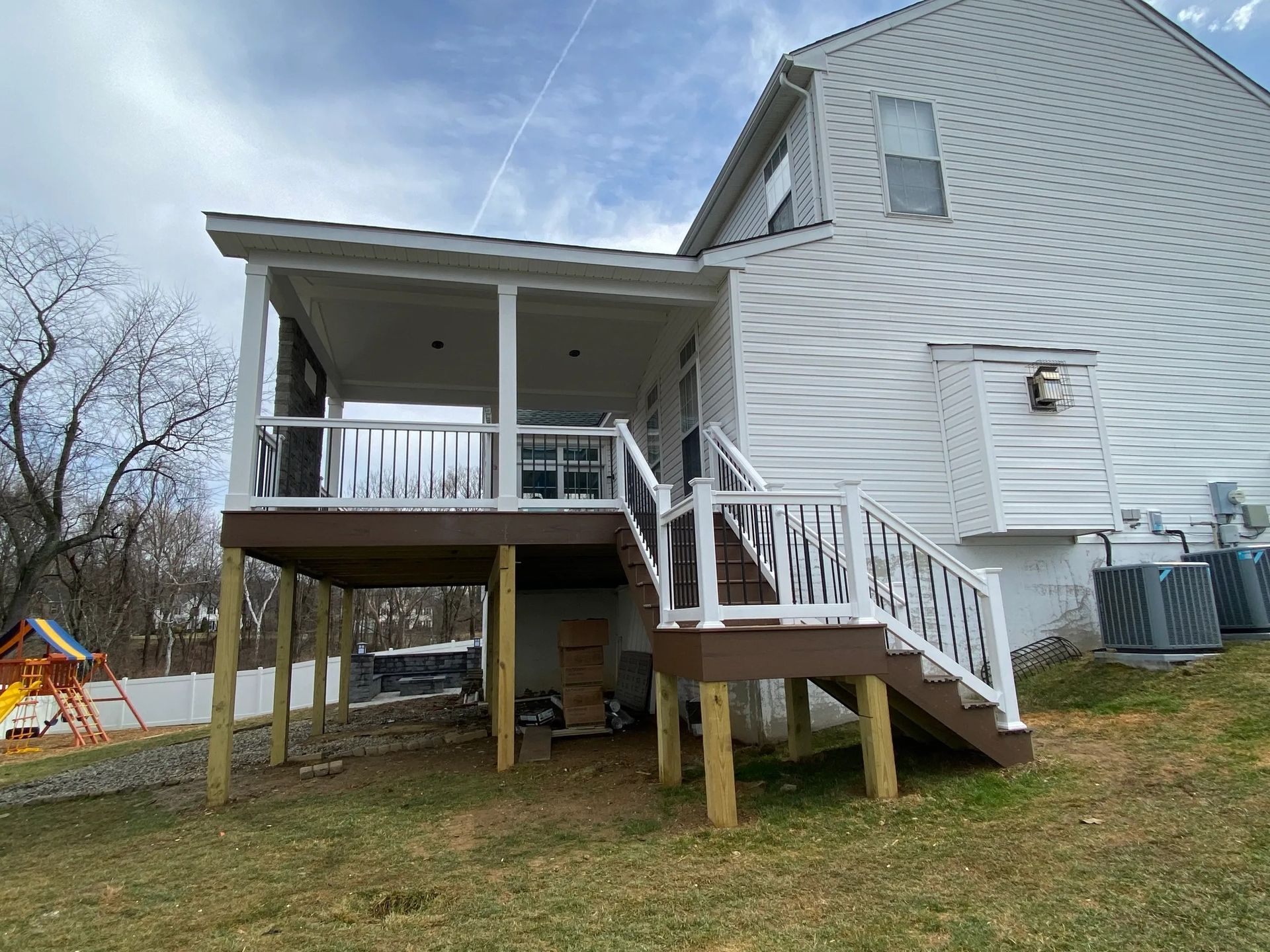 The back of a house with a deck and stairs.