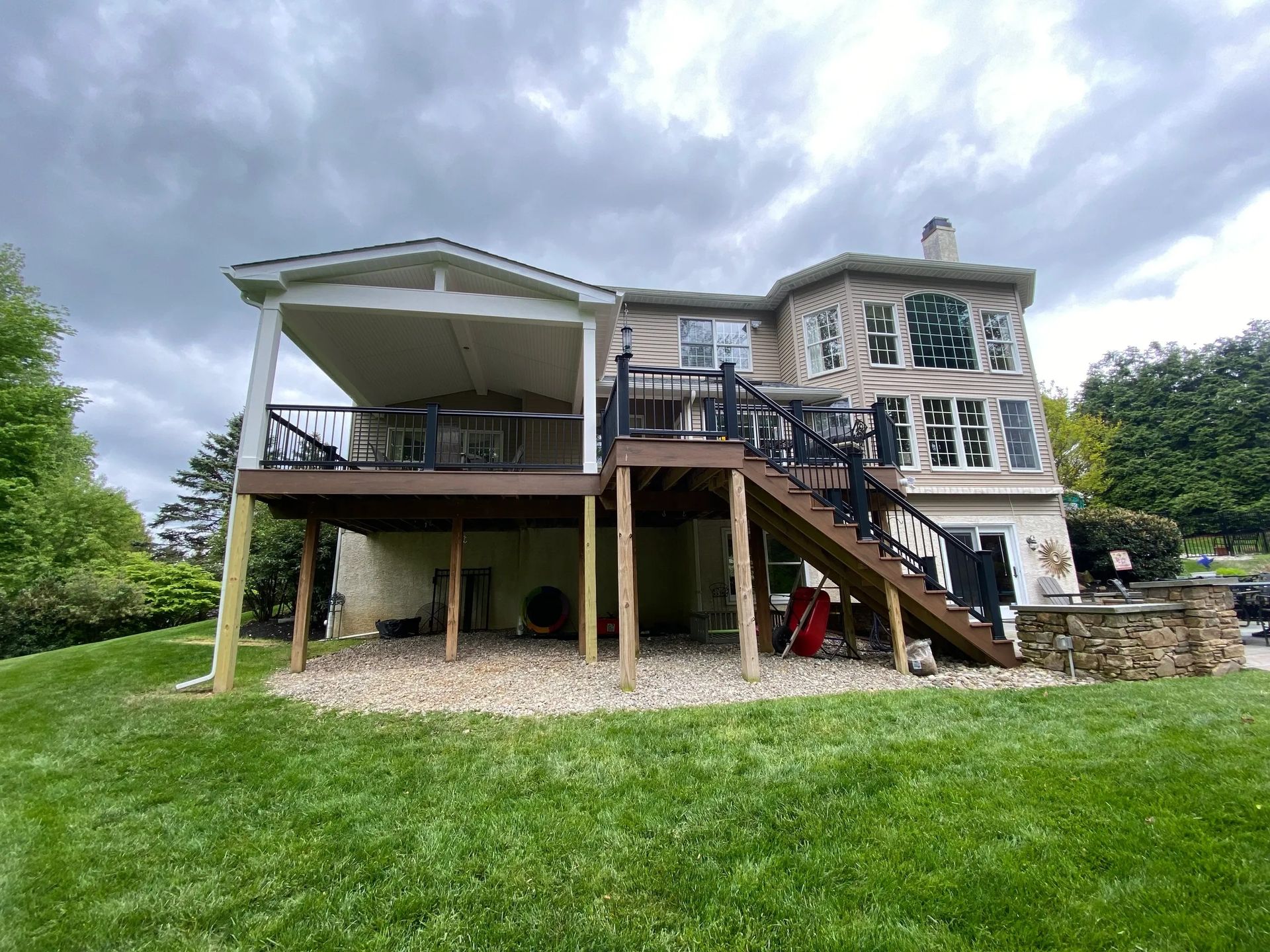 The back of a house with a large deck and stairs.