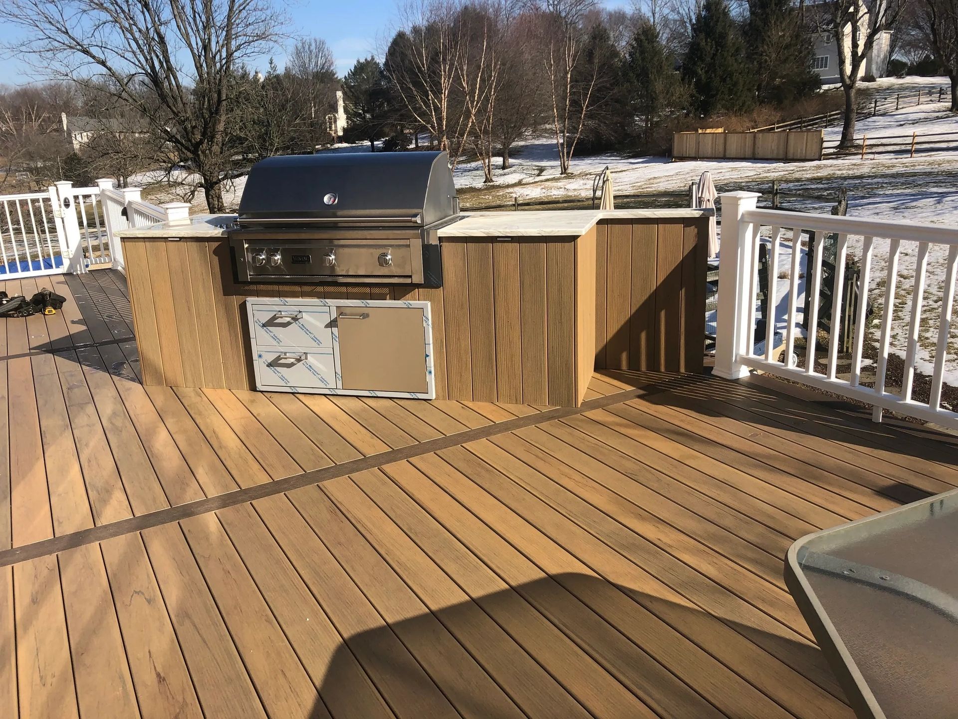 A wooden deck with a grill on top of it