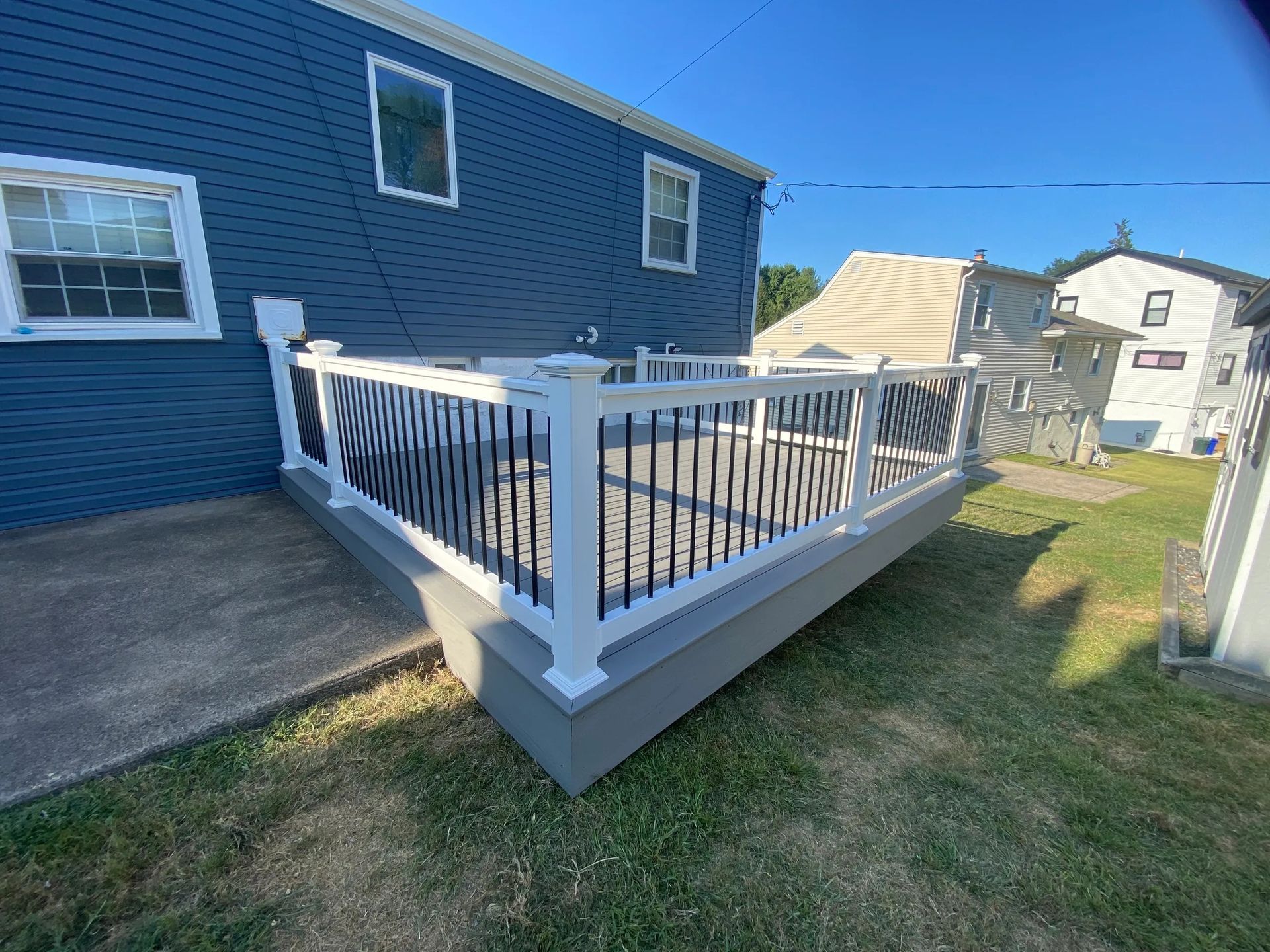 A blue house with a white deck in front of it.
