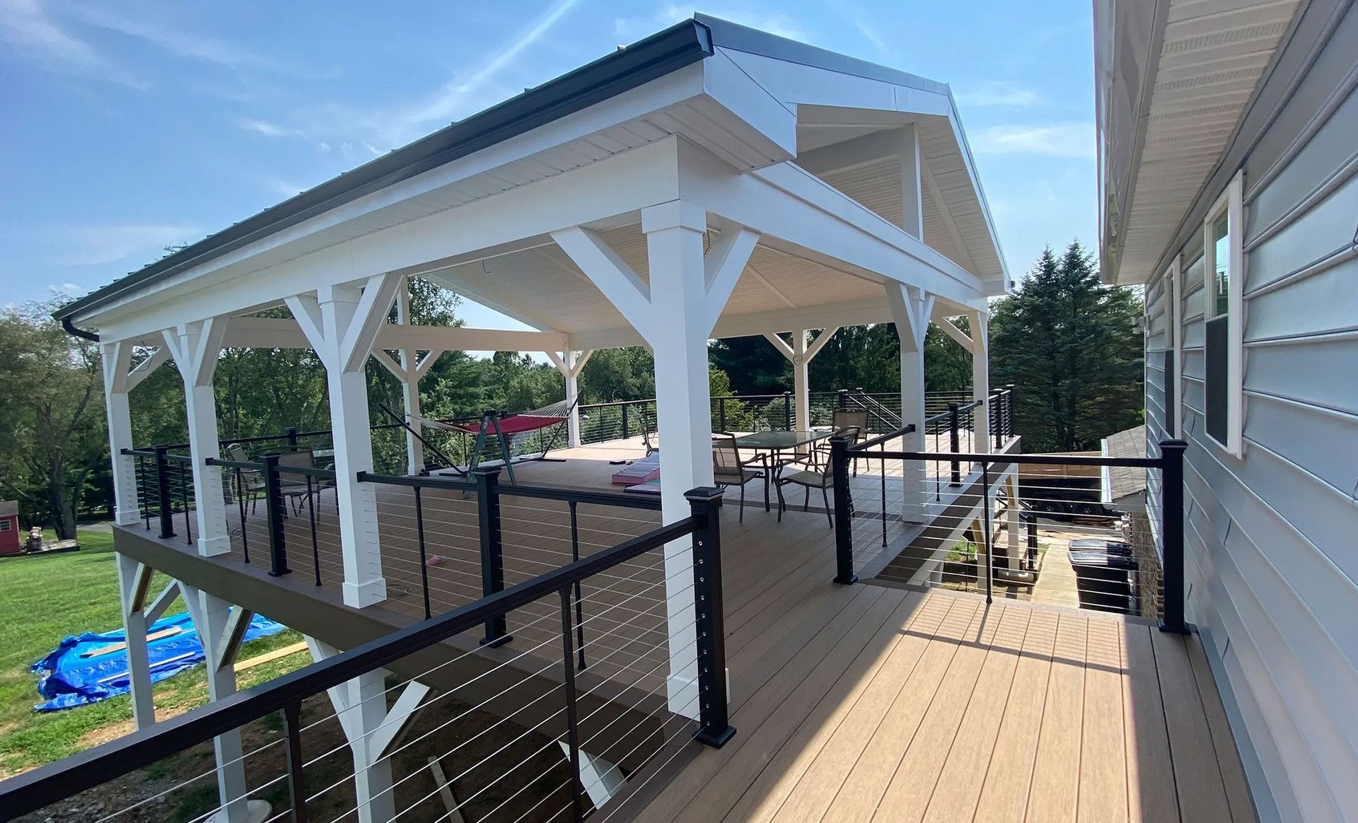 A large deck with a white roof and a black railing.