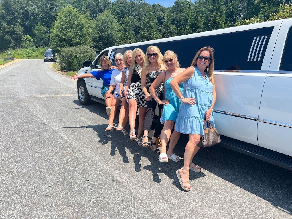 A group of women are standing in front of a white limousine.