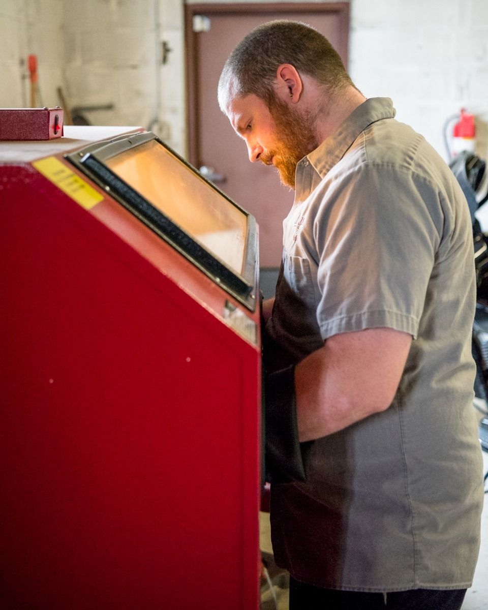 Person operating a red arcade machine indoors