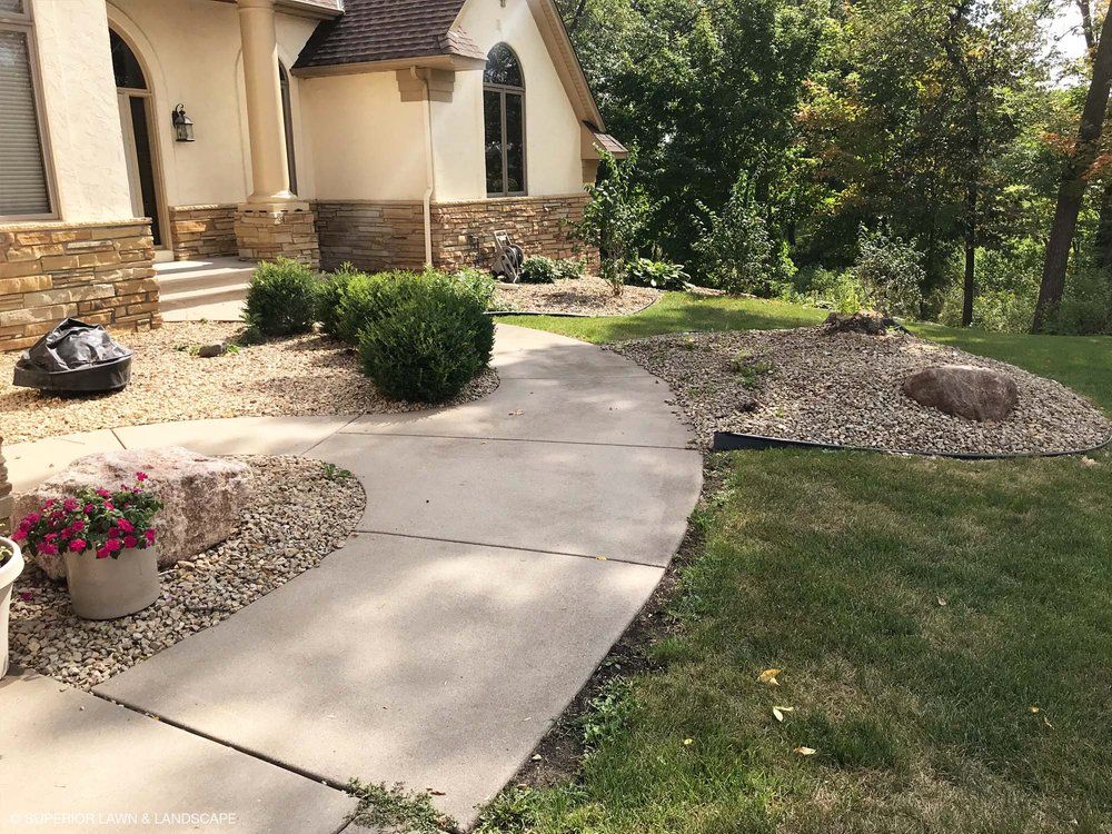 A concrete walkway leading to the front of a house.