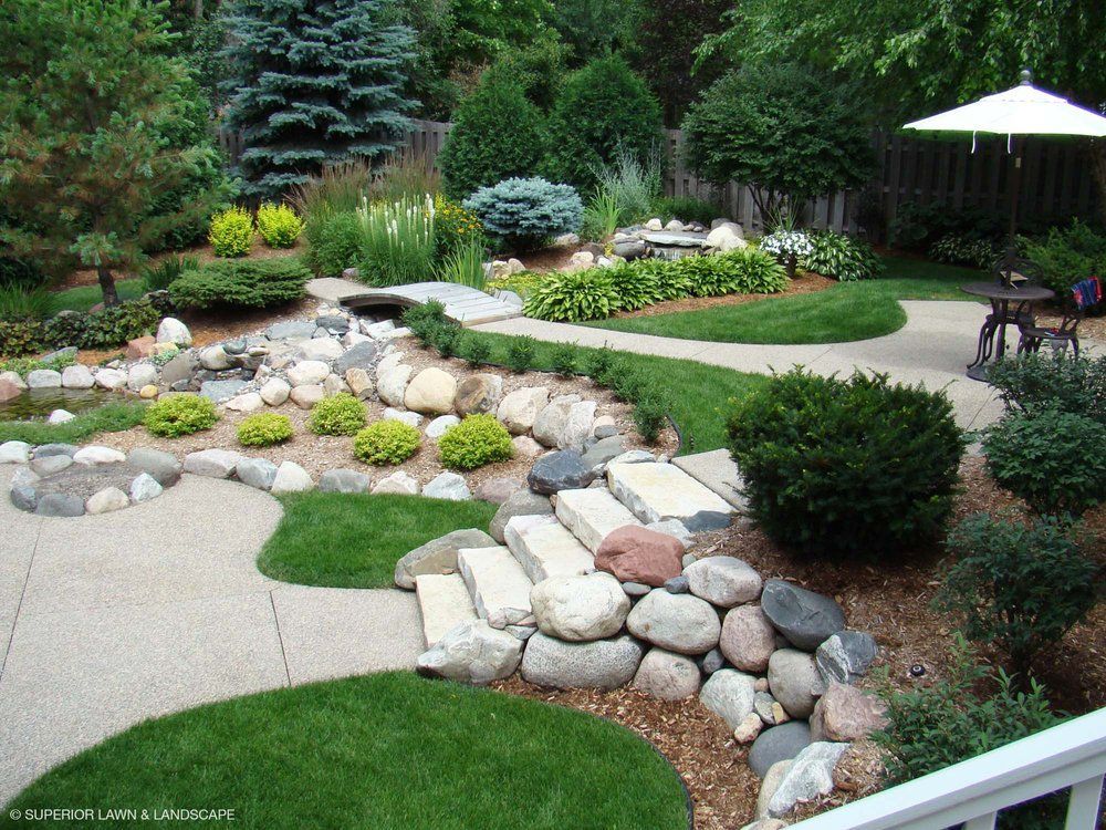 A lush green garden with a white umbrella in the background