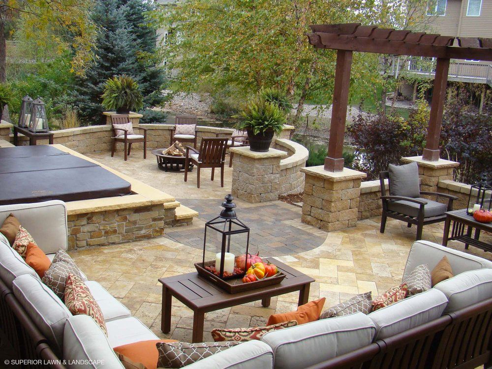 A patio with a couch a table and chairs and a hot tub