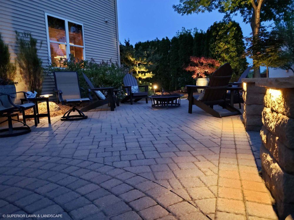 A patio with chairs and tables is lit up at night