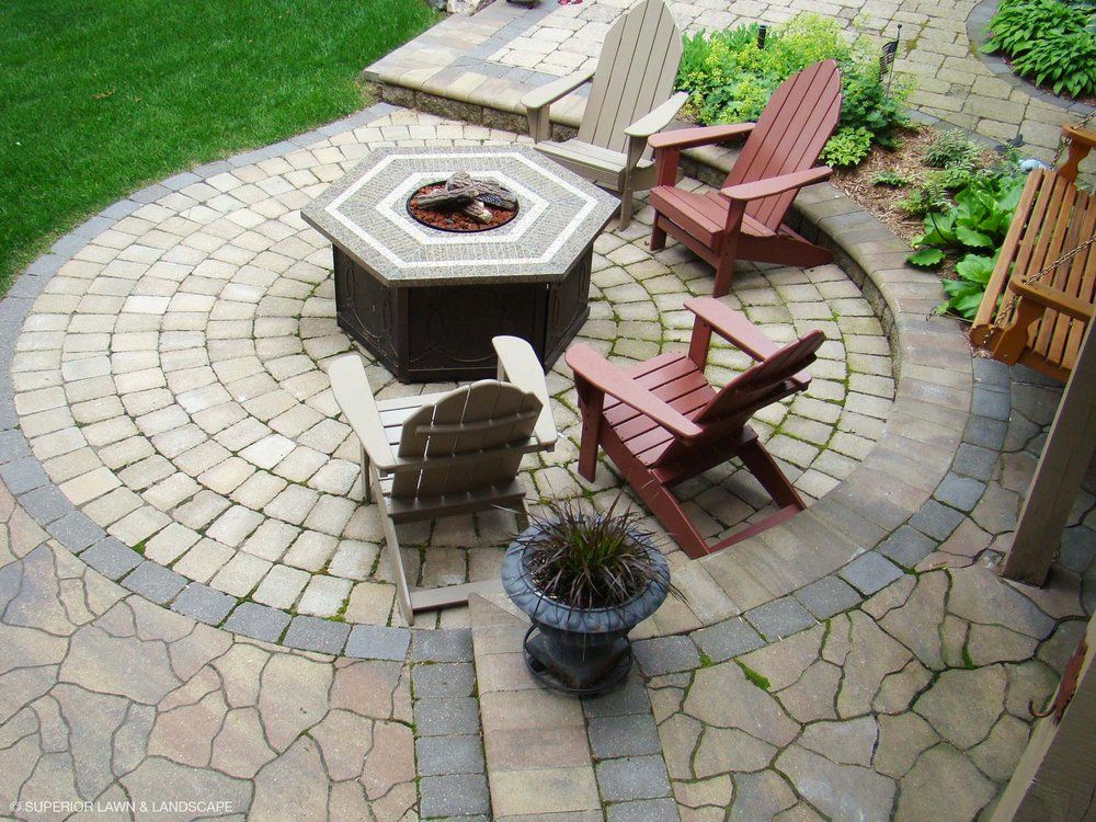 A patio with chairs and a fire pit in the middle