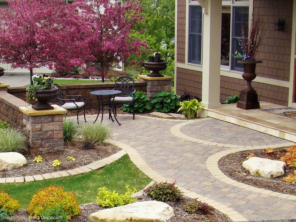 A patio with a table and chairs in front of a house