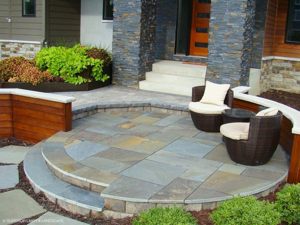 A patio with chairs and a table in front of a house