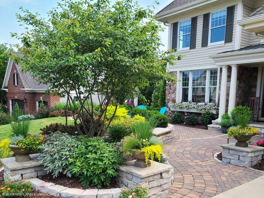 A large house with a lush green garden in front of it.