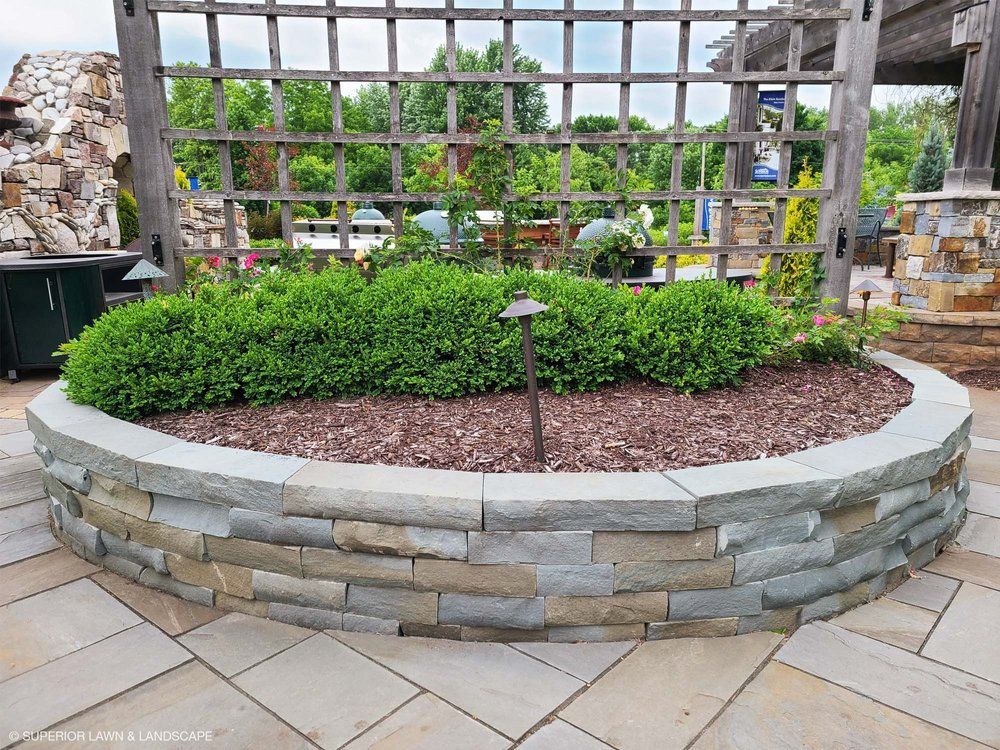 A stone wall with a planter in the middle of it