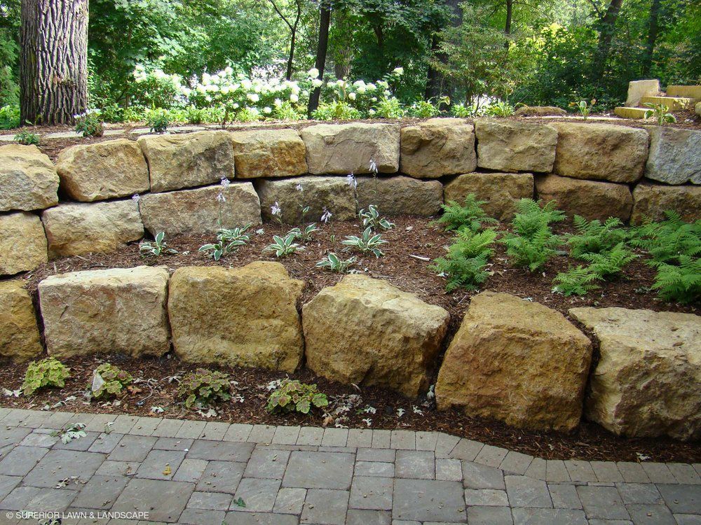 A brick walkway surrounded by rocks and plants in a garden