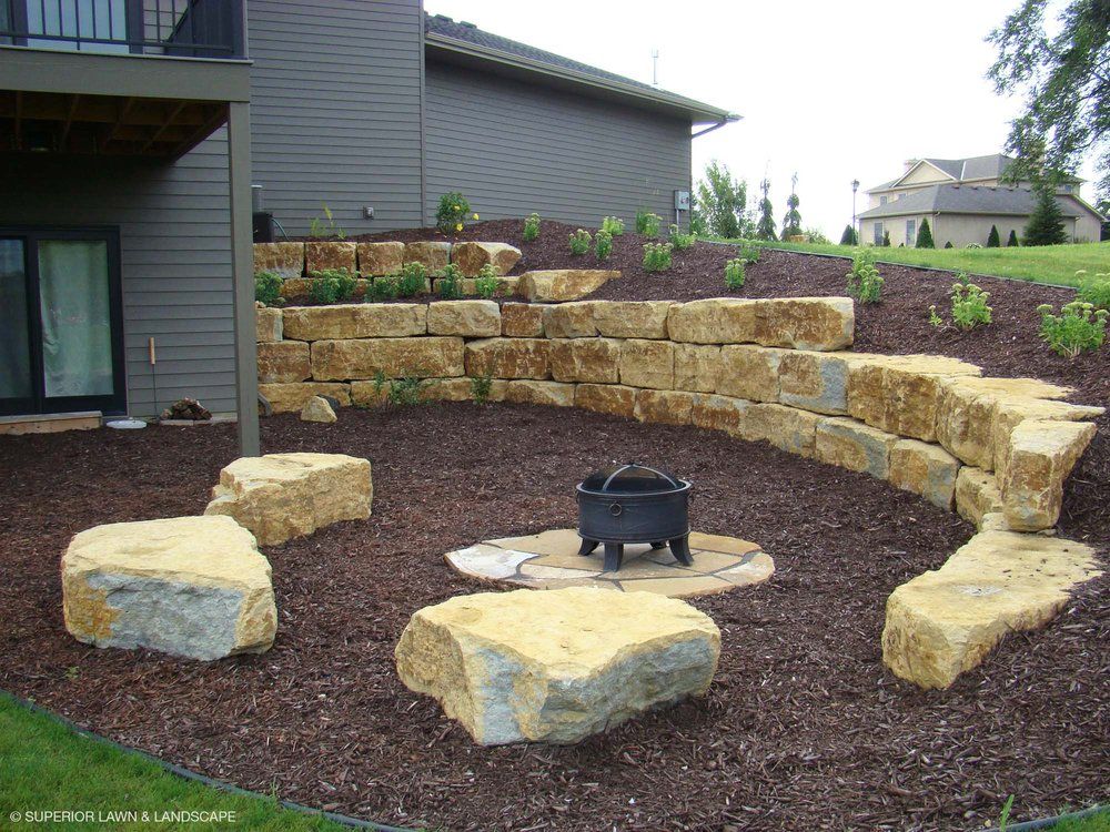 A fire pit surrounded by rocks in front of a house
