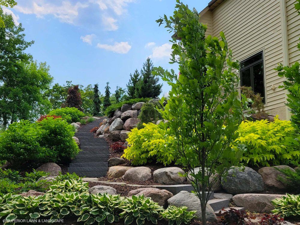 A house with a lush green garden in front of it.