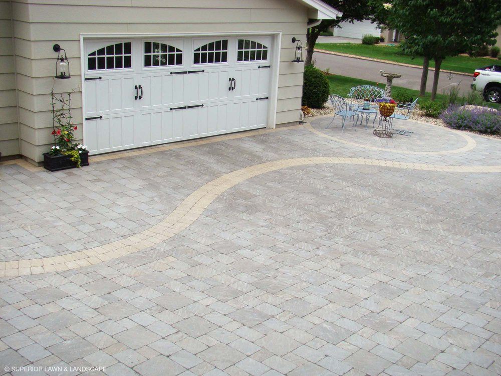 A white garage door with a patio in front of it
