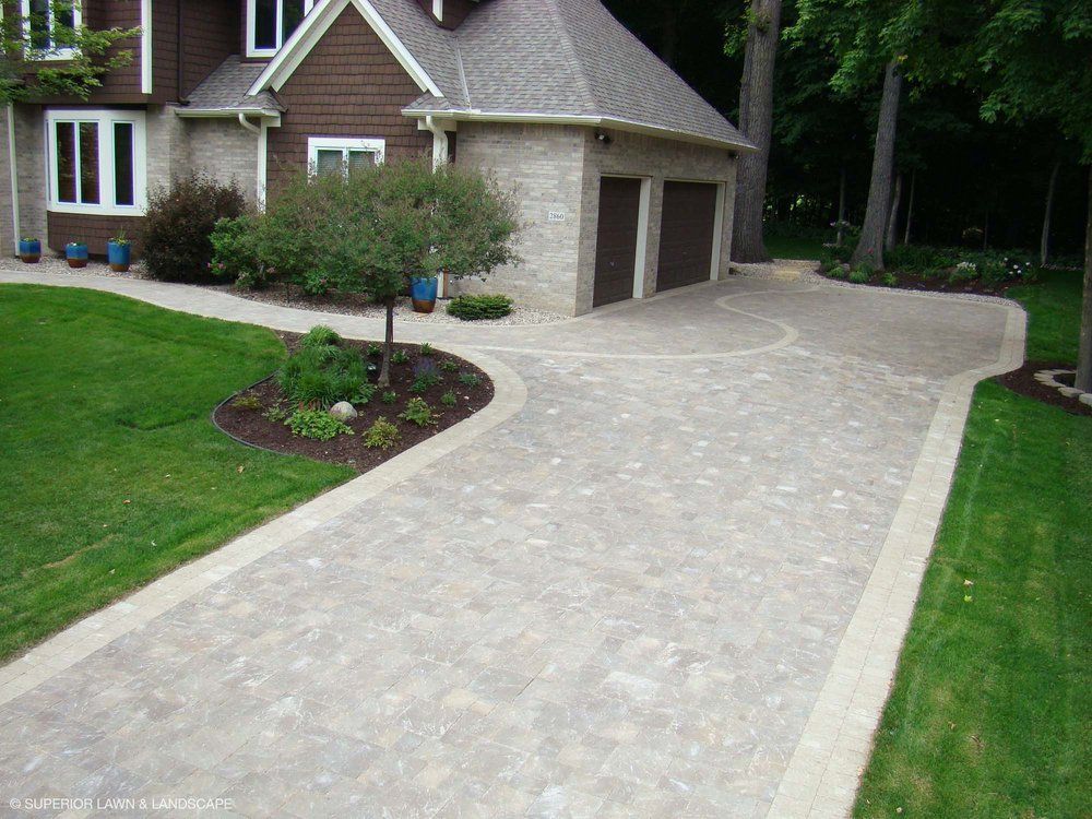 A driveway leading to a house with two garage doors
