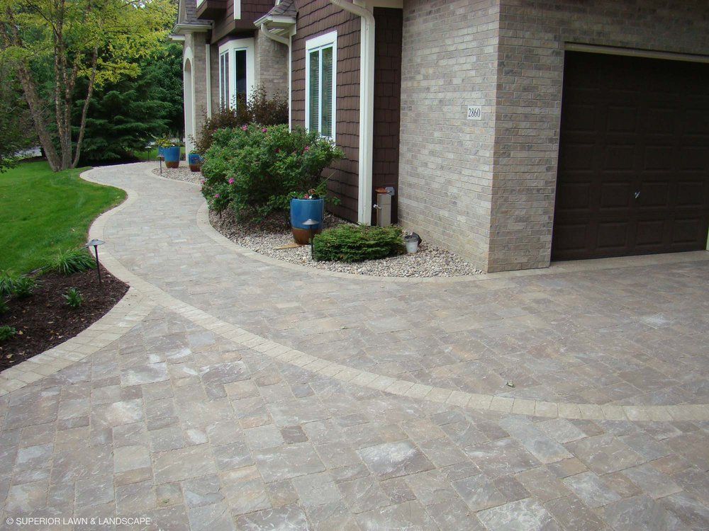 A driveway leading to a house with a garage door