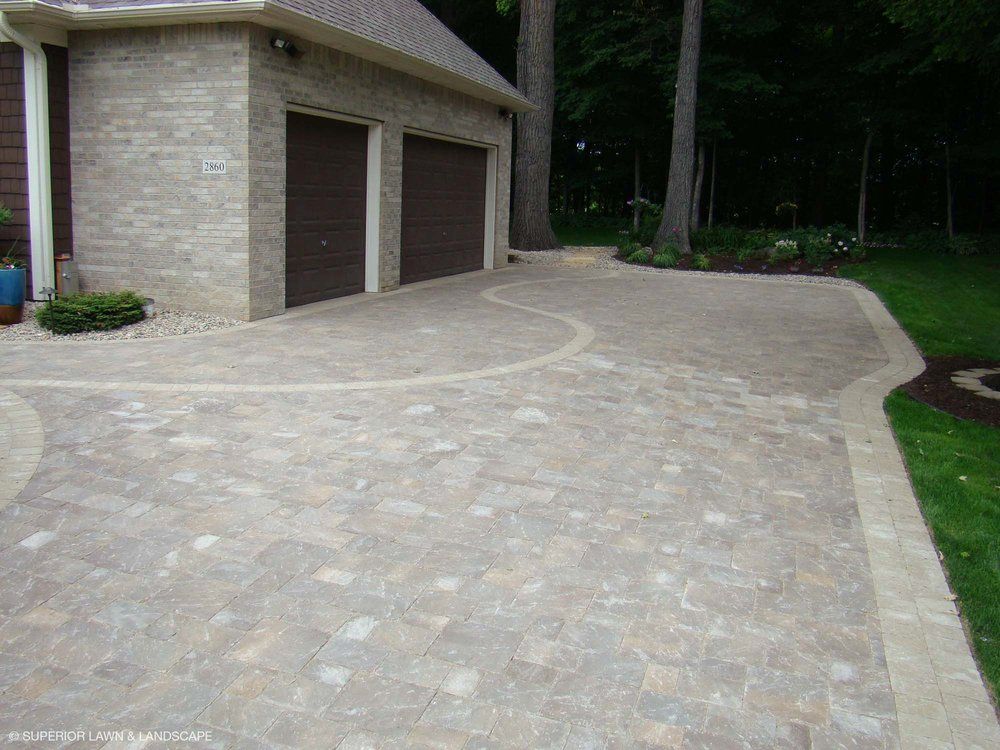 A driveway leading to a garage with two garage doors.