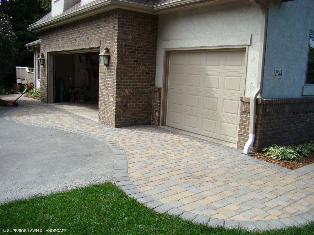 A house with two garage doors and a brick wall