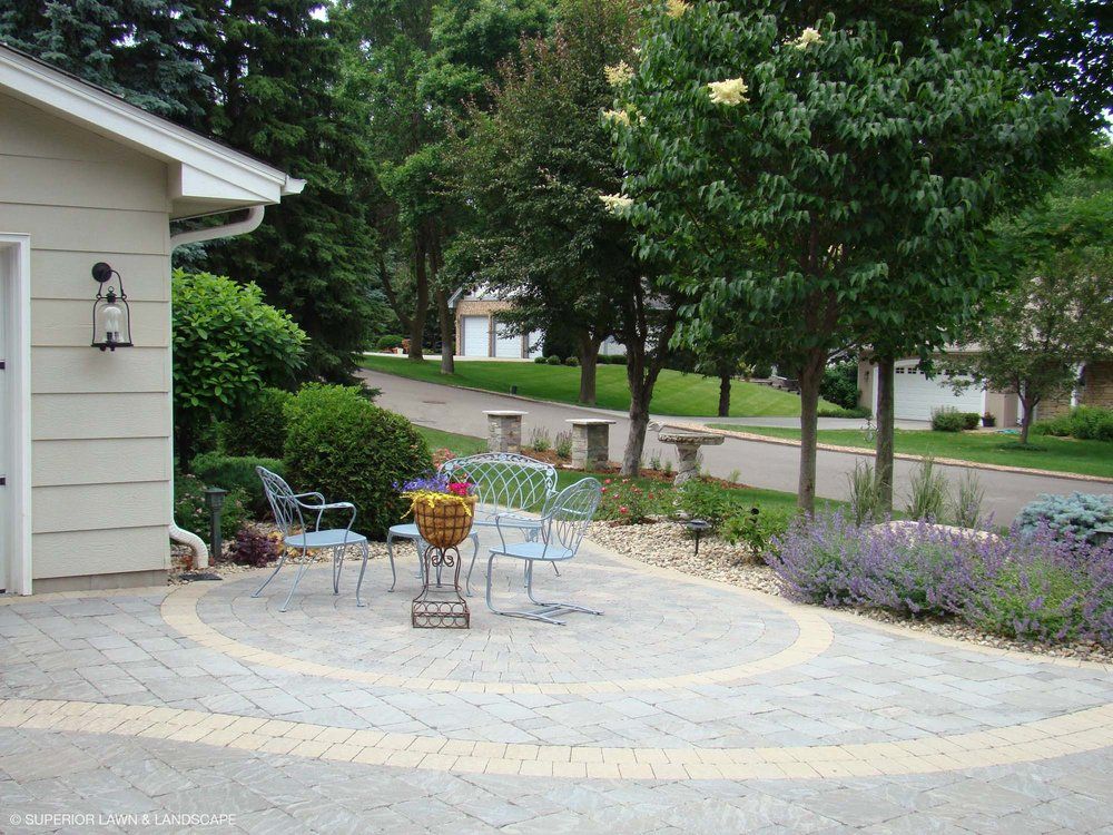 A patio with a table and chairs in front of a house