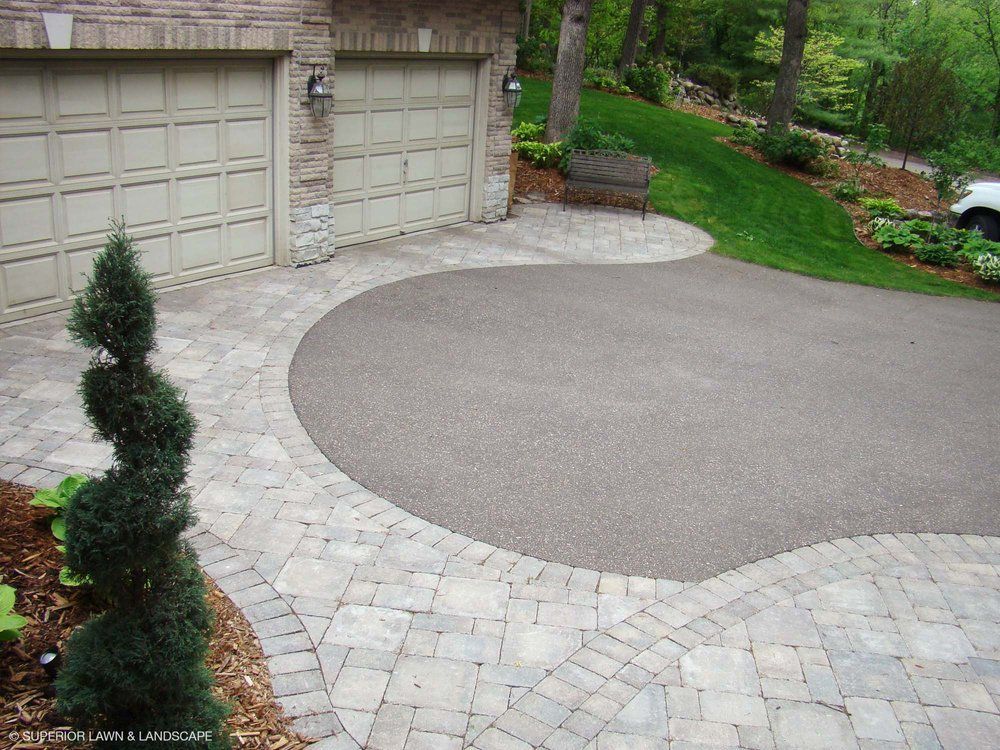 A car is parked in a driveway next to a garage