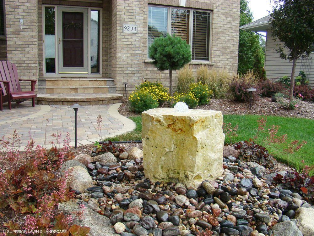 A brick house with a stone fountain in front of it