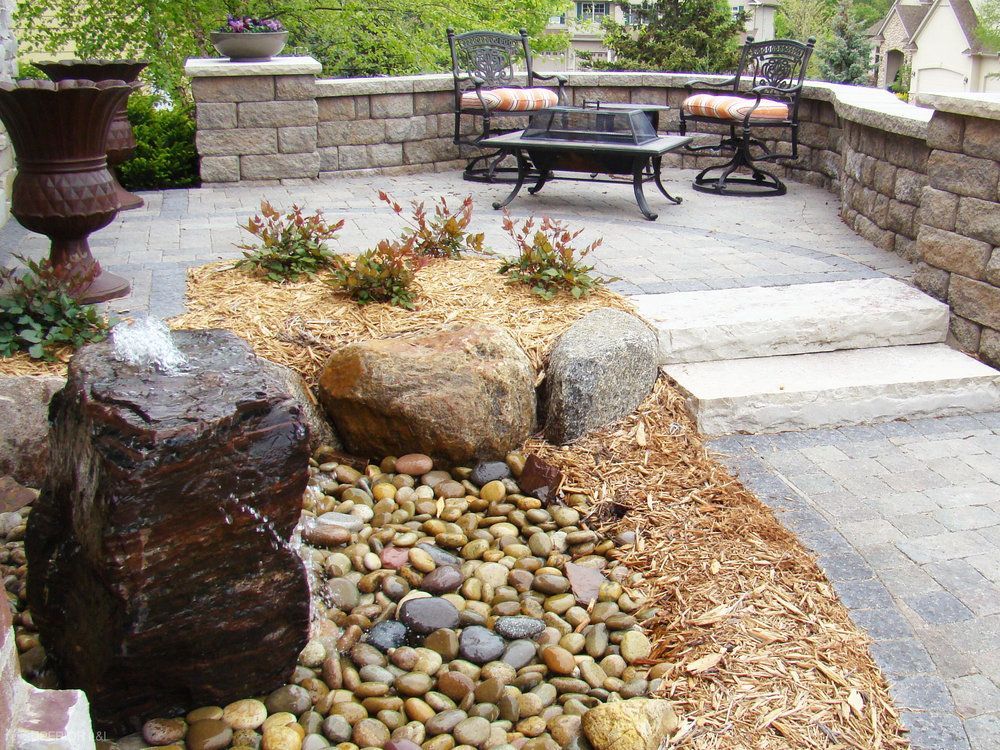 A patio with a table and chairs and a fountain