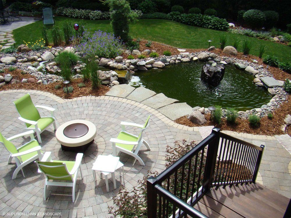 An aerial view of a patio with a fire pit and chairs