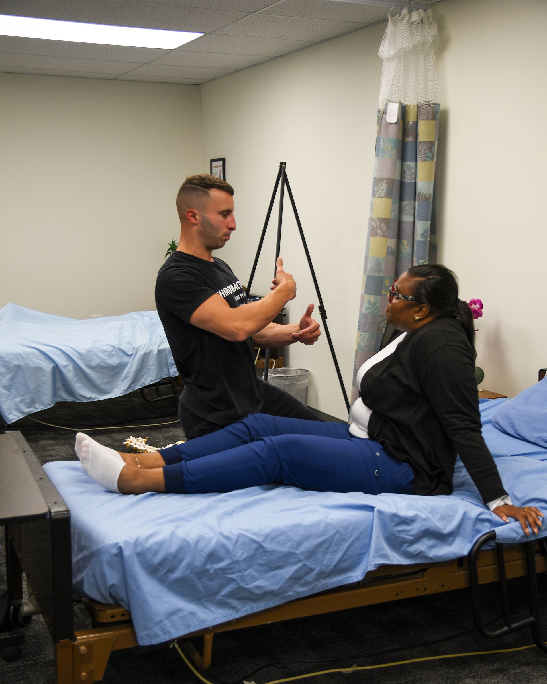 Man assisting woman on bed.