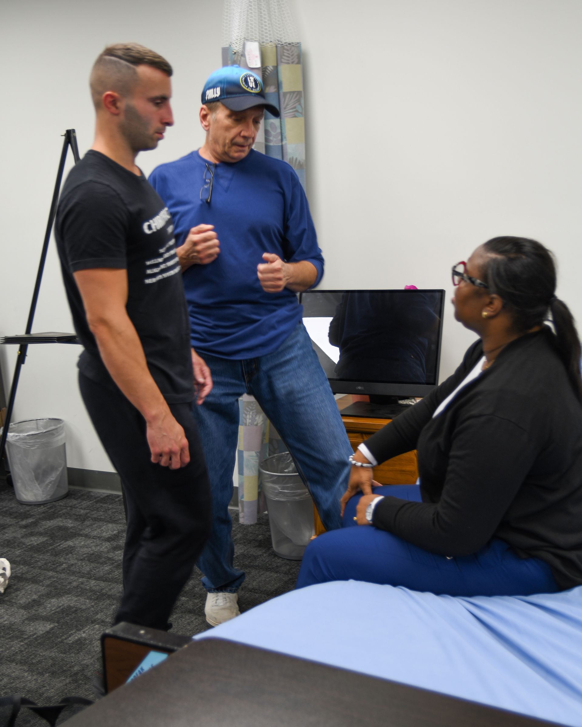 Three people talking in a healthcare setting.