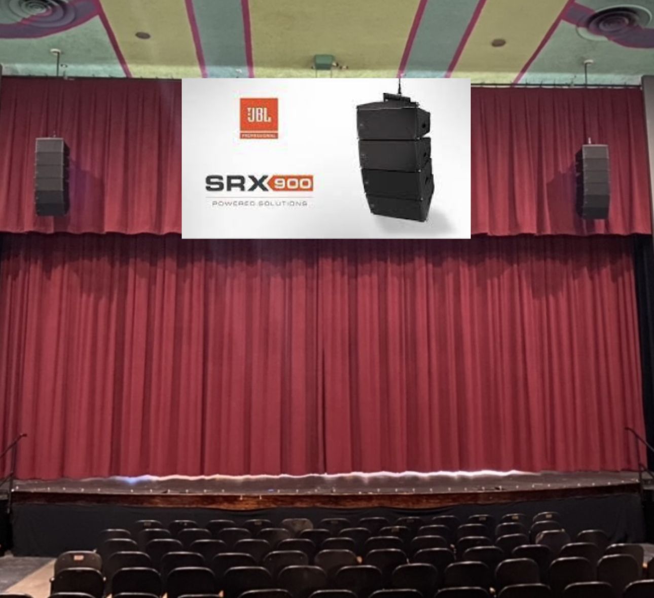 Stage with red curtains, JBL SRX800 speaker display, and audience seating.