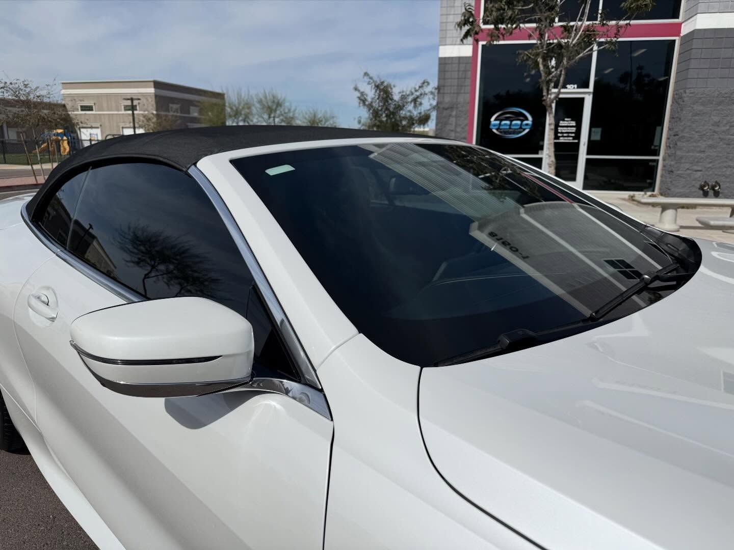 White car parked outside a building on a sunny day