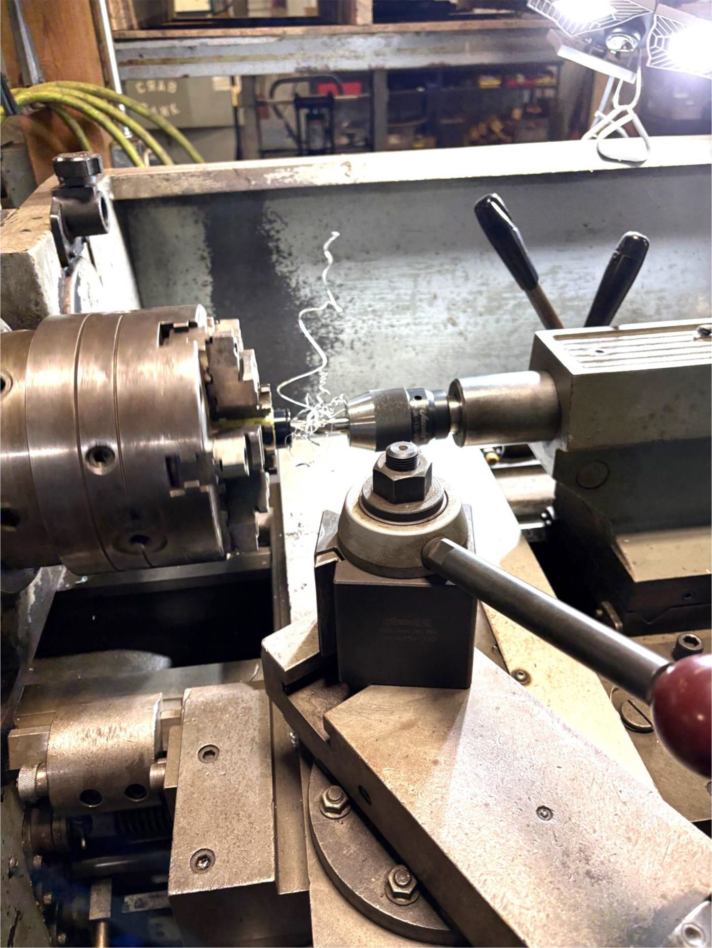 A lathe is being used to cut a piece of metal