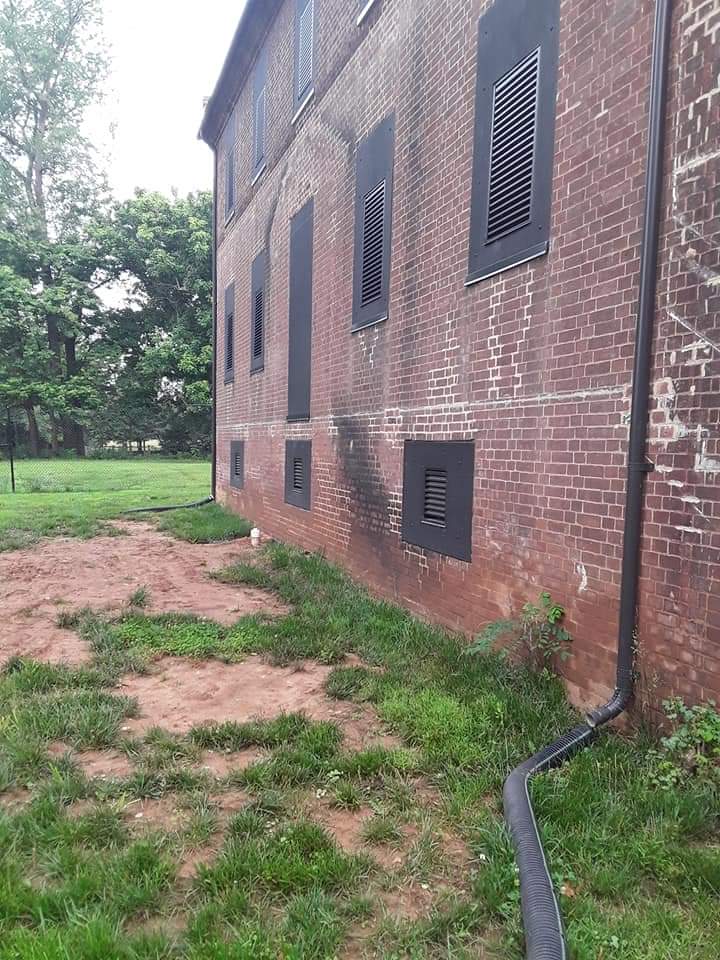 Exterior brick wall of a house next to an empty lot