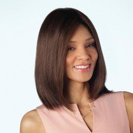 A woman wearing a pink shirt and a wig is smiling.