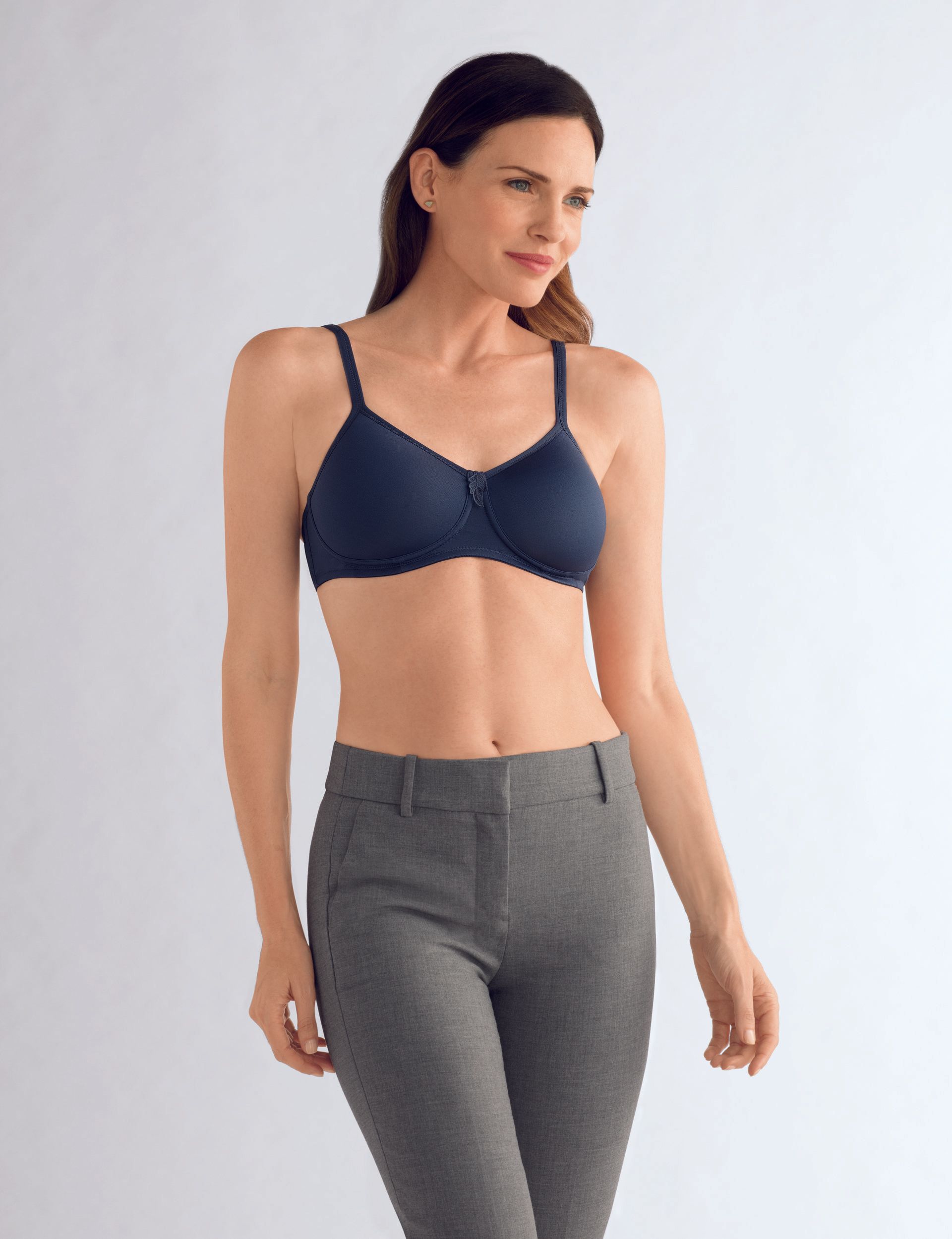 A woman is wearing a blue bra and grey pants.
