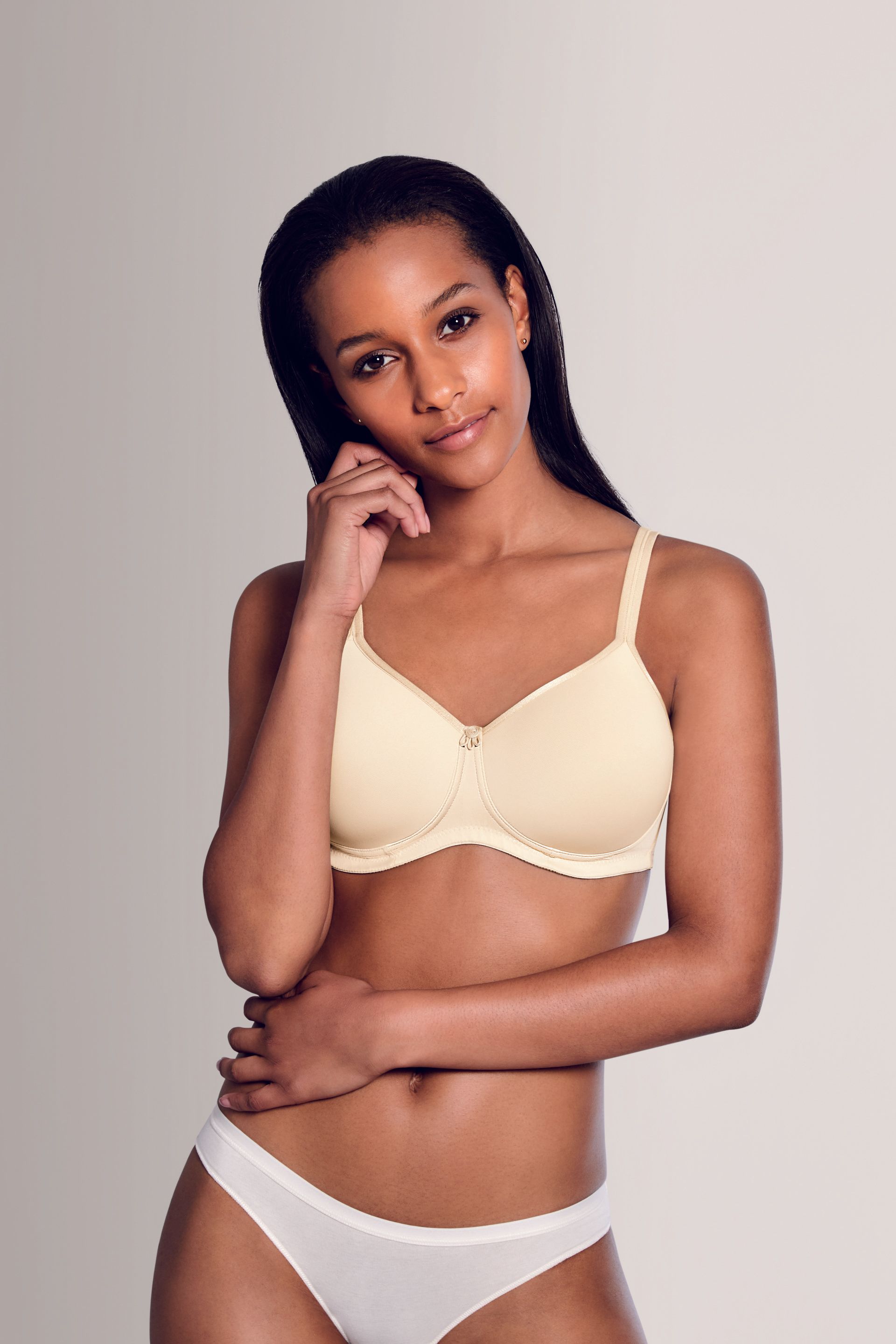 A woman is wearing a white bra and white underwear.