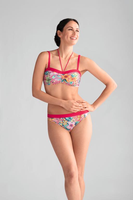 A woman in a bikini is standing with her hands on her hips.