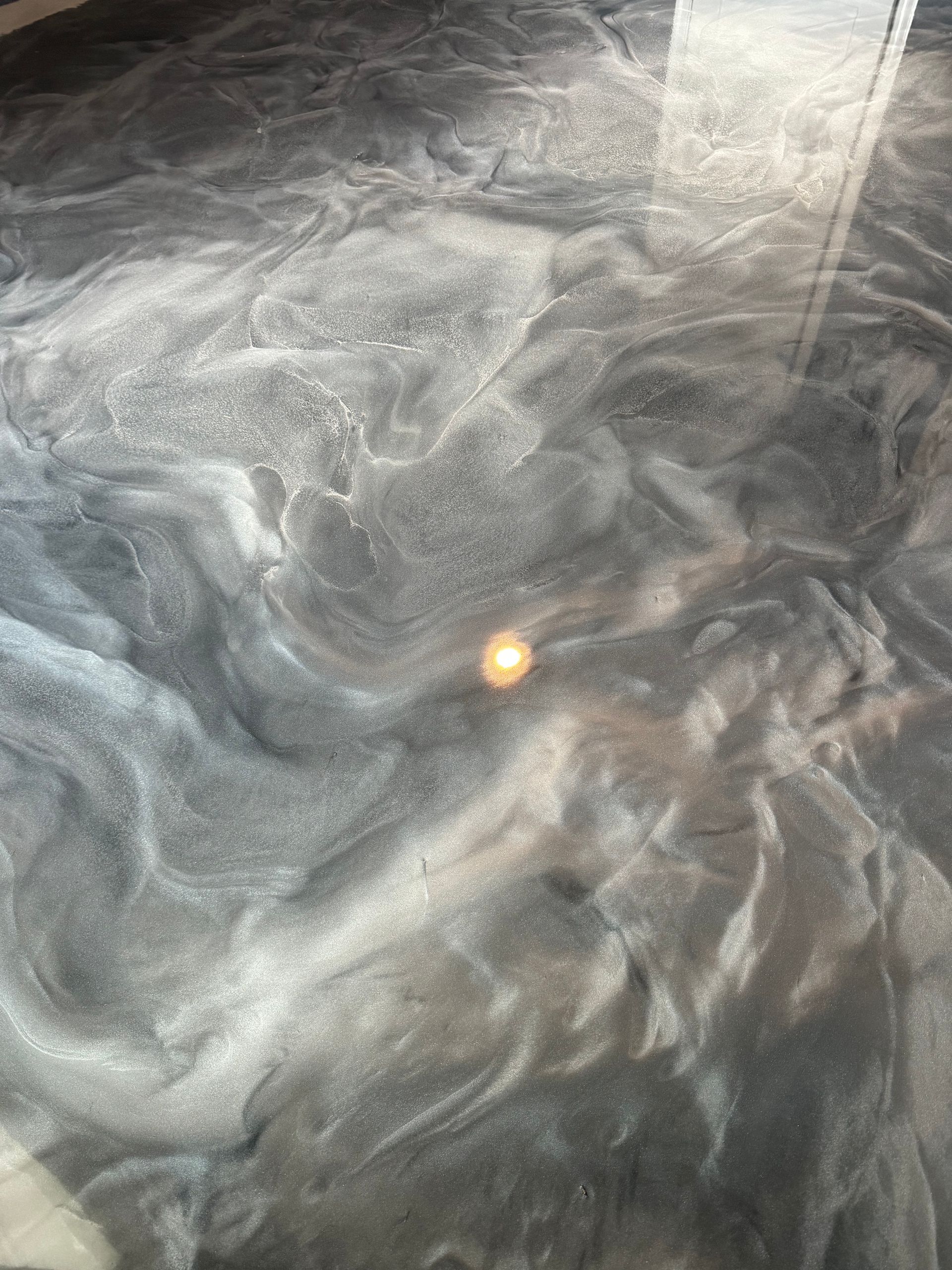 Gray smoky swirls with a small bright orange light near the center.