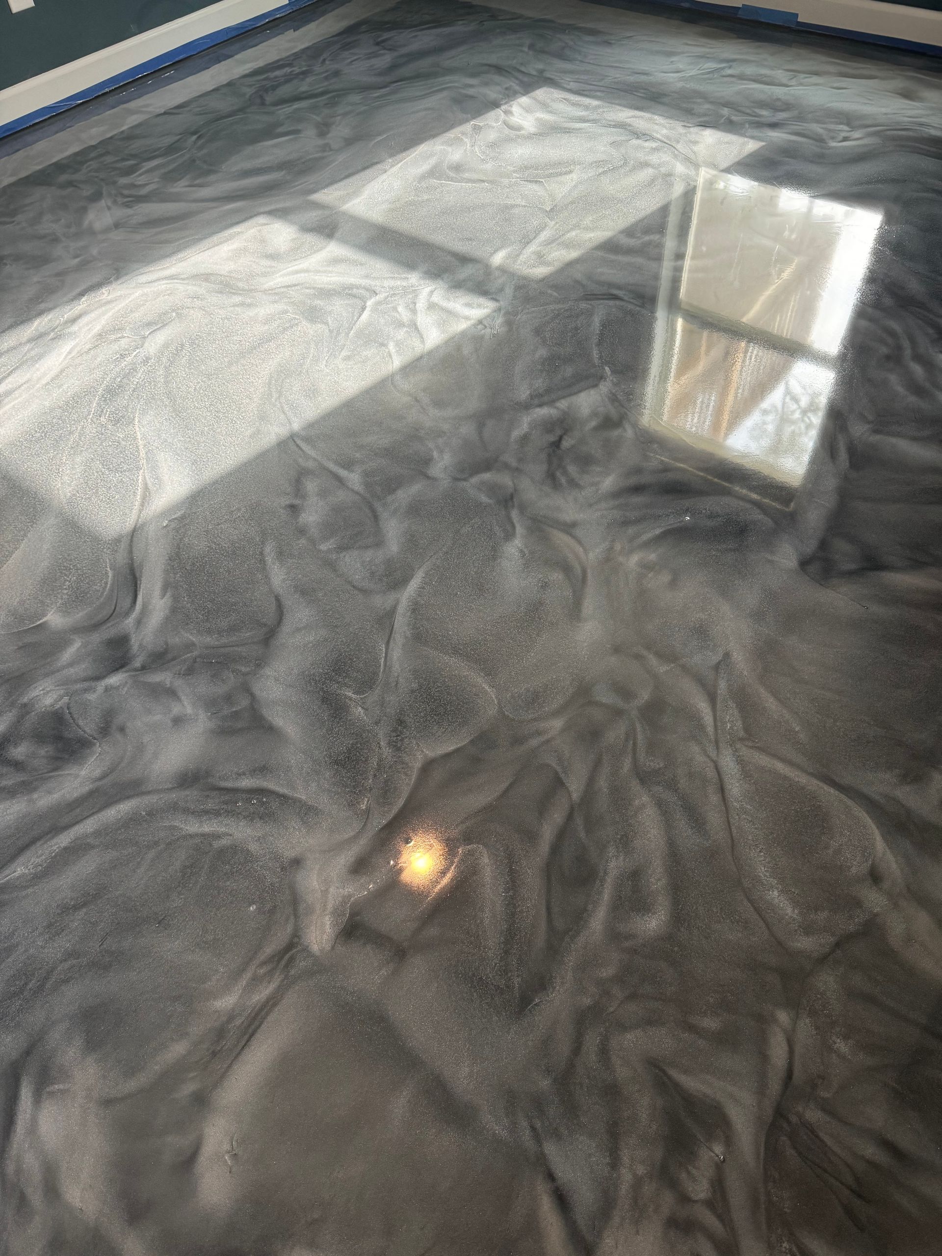 Sunlight on a dark textured fabric with a small reflective object nearby