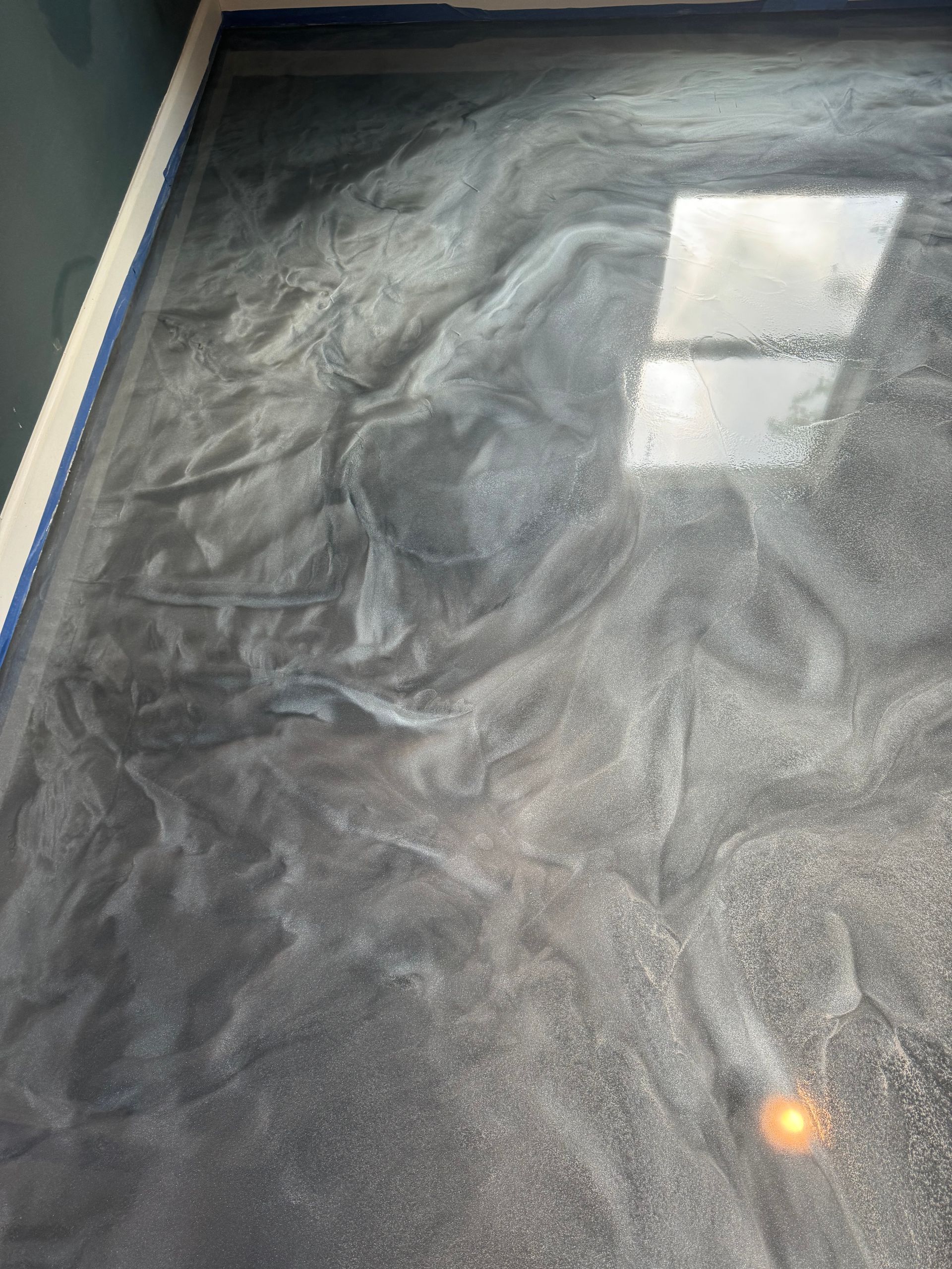 Marbled gray-black tabletop with a bright window reflection and a small orange light spot